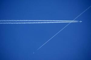 The trails in the sky that leave the planes in flight photo