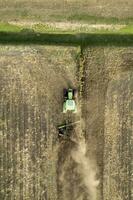 aéreo ver de un tractor a el hora de invierno suelo preparación foto