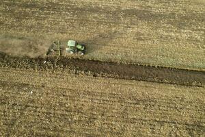 aéreo ver de un tractor a el hora de invierno suelo preparación foto