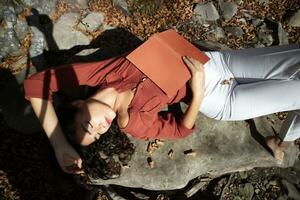 Beautiful girl reading in the woods in the autumn time photo