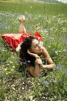 niña acostado abajo y relajado en un campo de flores foto