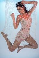 Beautiful girl imprisoned and caught in a net photo
