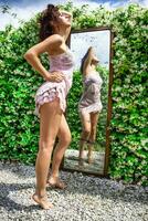 Beautiful girl in front of the mirror outdoors photo