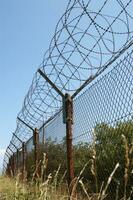 a barbed wire fence with a blue sky in the background photo