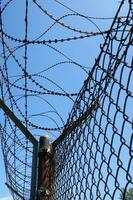 a barbed wire fence with a blue sky in the background photo