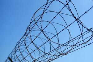 a barbed wire fence with a blue sky in the background photo