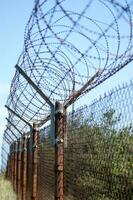 a barbed wire fence with a blue sky in the background photo