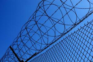 a barbed wire fence with a blue sky in the background photo