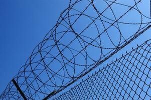 a barbed wire fence with a blue sky in the background photo