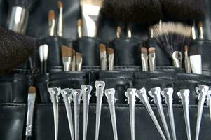 a black leather case with many brushes and other tools photo