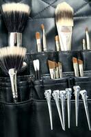 a black leather case with many brushes and other tools photo