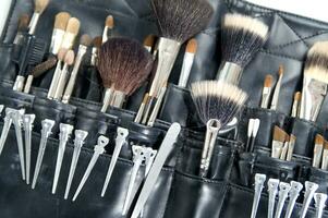 a black leather case with many brushes and other tools photo