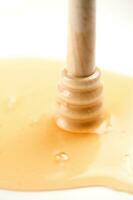 honey dripping from a wooden stick photo