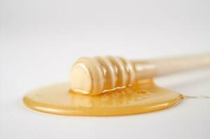 honey dripping from a wooden stick photo