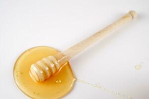 honey dripping from a wooden stick photo