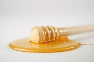 honey dripping from a wooden stick photo