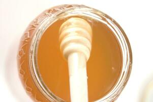 honey dripping from a wooden stick photo