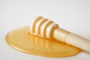 honey dripping from a wooden stick photo