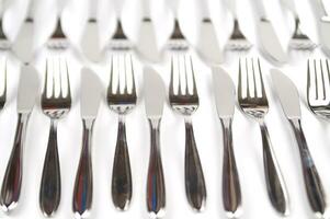 many forks and knives are arranged in a pile photo