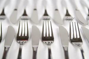 many forks and knives are arranged in a pile photo