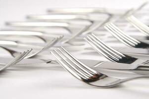 many forks and knives are arranged in a pile photo