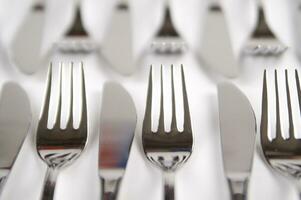 many forks and knives are arranged in a pile photo