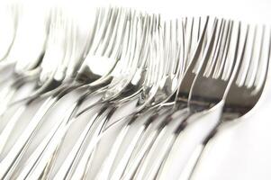 many forks and knives are arranged in a pile photo