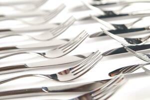 many forks and knives are arranged in a pile photo