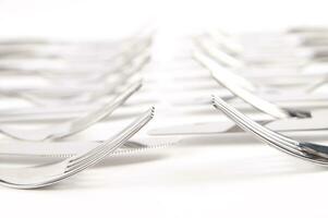 many forks and knives are arranged in a pile photo