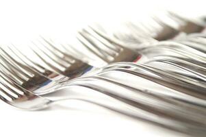 many forks and knives are arranged in a pile photo