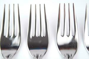 many forks and knives are arranged in a pile photo