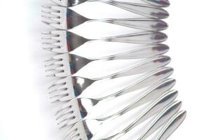 many forks and knives are arranged in a pile photo