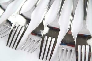 many forks and knives are arranged in a pile photo