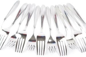 many forks and knives are arranged in a pile photo