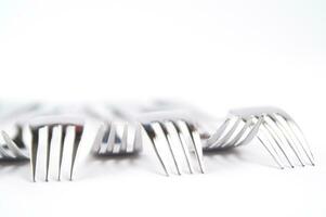 many forks and knives are arranged in a pile photo