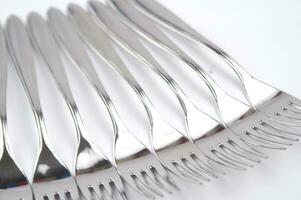 many forks and knives are arranged in a pile photo