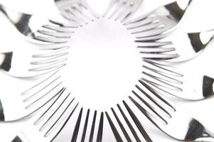 many forks and knives are arranged in a pile photo