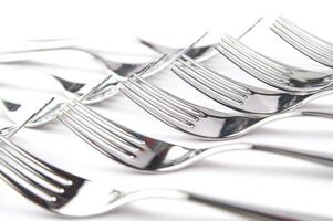 many forks and knives are arranged in a pile photo