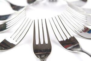 many forks and knives are arranged in a pile photo