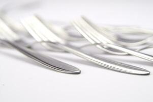 many forks and knives are arranged in a pile photo