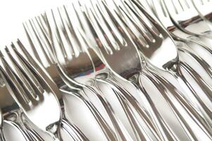 many forks and knives are arranged in a pile photo