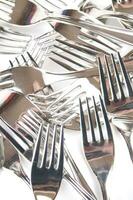many forks and knives are arranged in a pile photo