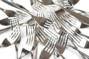 many forks and knives are arranged in a pile photo