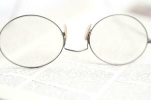 a pair of glasses is sitting on top of an open book photo