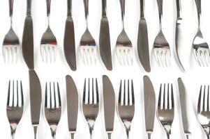 many forks and knives are arranged in a pile photo