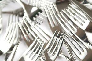 many forks and knives are arranged in a pile photo