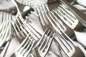 many forks and knives are arranged in a pile photo