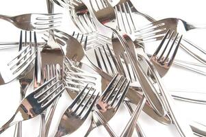 many forks and knives are arranged in a pile photo