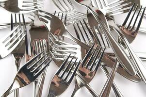 many forks and knives are arranged in a pile photo