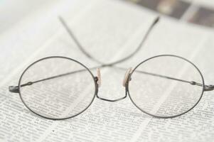 un par de lentes es sentado en parte superior de un abierto libro foto